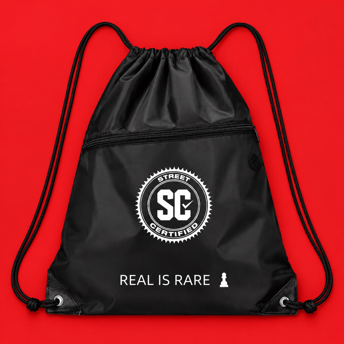 Street Certified Real Is Rare Drawstring Bag in Black on a red background