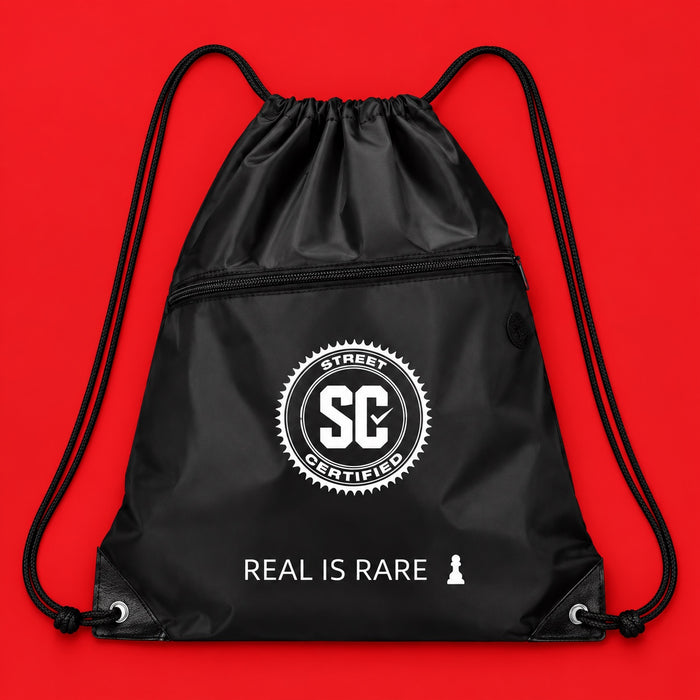 Street Certified Real Is Rare Drawstring Bag in Black on a red background